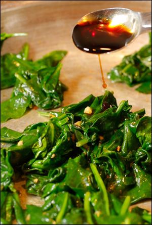 Soy sauce is added to spinach sauteed in garlic.