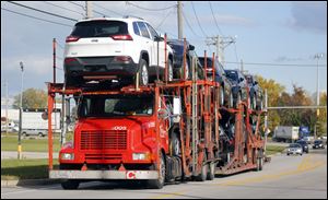 Jeep Cherokees are transported to Cassens Transport Co. on Matzinger Road,  Wednesday, October 23, 2013. 