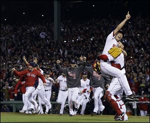 Boston Red Sox relief pitcher Koji Uehara and catcher David Ross celebrate after getting St. Louis Cardinals' Matt Carpenter to strike out and end Game 6 of baseball's World Series Wednesday, Oct. 30, 2013, in Boston. The Red Sox won 6-1 to win the series.