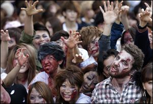 Participants in zombie costumes, perform during a Halloween event at Tokyo Tower today.