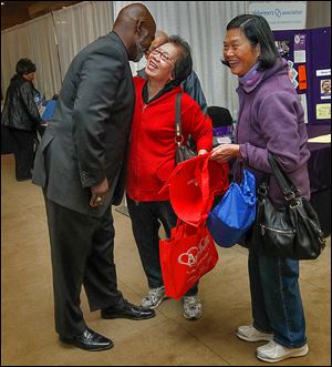 Toledo Mayor Mike Bell is greeted by Wan Sung Leung during the annual Caregiver Expo at Parkway Plaza in Maumee, one of several events on his calendar Saturday.