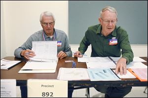 Bob Gyori, left, and Wayne Johnson sign people in to vote at the Rossford Board of Education's Bulldog Hall. Voters rejected a proposal for new school construction.