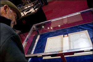 A visitor looks at Napoleon's will displayed at an auction house in Paris, France, Tuesday.