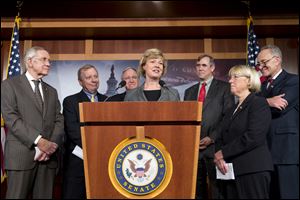 Sen. Tammy Baldwin, D-Wis., center, the Senates first openly gay member, is surrounded by fellow Democrats just before a historic vote on legislation outlawing workplace discrimination against gay, bisexual and transgender Americans today on Capitol Hill in Washington. 