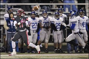 Central Catholic’s Jermiah Braswell catches a pass in front of Defiance’s Trey Guilliam Friday night in a Division III first-round playoff game. The Irish improved to 11-0.