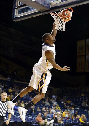 University of Toledo player Rian Pearson (5) dunks against Northwestern Ohio University player Austin Hintz (12) during the first half of their game at Savage Arena, Saturday.