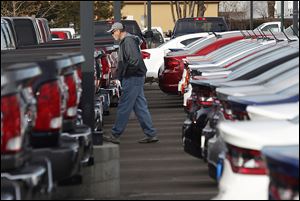 A buyer moves between rows of 2013 Ram pickup trucks and Dart sedans at a Dodge dealership in Littleton, Colo.  Buyers with imperfect credit account for 27 percent of loans for new vehicles.