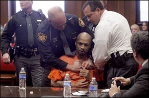 Authorities subdue Curtis Clinton, center, as he engages in words with Nick Fee, brother of murder victim Heather Jackson, after Clinton was sentenced to the death penalty for the 2012 slayings of Ms. Jackson and her children, Celina Jackson, 3, and Wayne Jackson, Jr., 20 months.