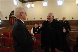 Martin, left, greets Bishop Leonard Blair before speaking to the group.