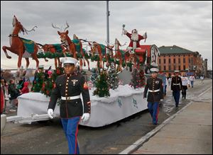 Santa Claus rrives with his sleigh of reindeer, escorted by members of the U.S. Marine Corps, as The Blade’s 26th Annual Holiday Parade, sponsored by The Taylor Automotive Family, makes its way down Summit Street.