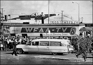 People line the street as the hearse bearing the body of President John F. Kennedy leaves Parkland Hospital in Dallas.