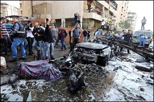 Lebanese people gather at the scene where two explosions have struck near the Iranian Embassy killing many, in Beirut, Lebanon, Tuesday.