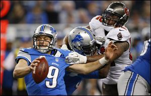 Buccaneers outside linebacker Jonathan Casillas, right, reaches out to grab Lions quarterback Matthew Stafford during the fourth quarter Sunday at Ford Field in Detroit. Stafford threw four interceptions, and the Lions finished with five in the loss.