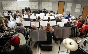 The Owens College Community Concert Band rehearses. The band will help ring in the holidays next month with a performance to raise money for St. Paul’s Community Center.