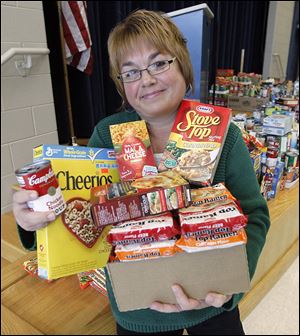 Reka Monus, coordinator for Crossroads Family Resource Center, holds a few of the canned and boxed foods collected for her organization by DeVeaux Elementary School students.