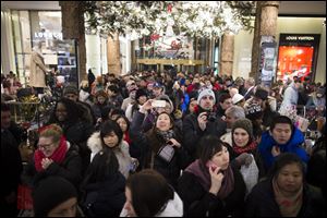 A shopper takes a selfie as crowds pour into the Macy's Herald Square flagship store Thursday in New York. 