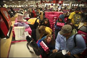 A crowd scrambled to find sizes of boots on sale soon after the doors opened at 8 p.m. for Black Friday shopping at Kohls on Thursday in Roseville, Minn.