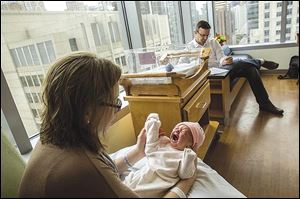 Zachary Bambacht spends time with his wife, Katie, and their 2-day-old daughter, Evie, in the postpartum department at Prentice Hospital in Chicago.