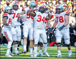 Ohio State running back Carlos Hyde (34) celebrates after scoring the final touchdown for the Buckeyes against Michigan during the fourth quarter. He ran for a game-high 226 yards.