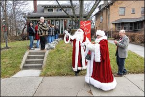 Gary Douglass as Santa and Ellen Langel as Mrs. Claus  greet guests lined up outside the home at 2636 Parkwood Ave. during the annual Tours de Noel through the Old West End.