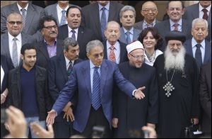 Amr Moussa, center, the chairman of Egypt's 50-member panel tasked with amending Egypt's Islamist-drafted constitution, arranges the members for a group picture after finishing the final draft of a series of constitutional amendments at the Shoura Council in Cairo, Egypt today.