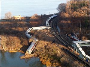 Cars from a Metro-North passenger train are scattered after the train derailed in the Bronx borough of New York, Sunday.