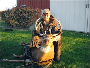 Russell Strayer of Liberty Center shows off a 10-point white-tailed buck he harvested with a crossbow.