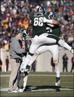 Tyler Hoover, right, celebrates his fumble recovery with Michigan State teammate Micajah Reynolds during Saturday’s win.
