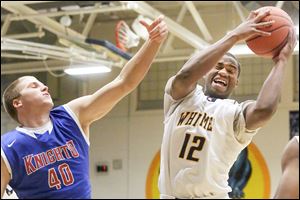 Whitmer’s Kemontrece Collins, right, pulls down a rebound over St. Francis’ Jacob Lang.