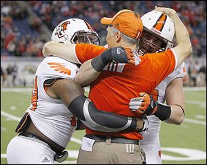 Bowling Green’s Jerry ‘Boo Boo’ Gates, left, and Paul Swan celebrate with head coach Dave Clawson after the Falcons defeated Northern Illinois to win their first MAC title since 1992.