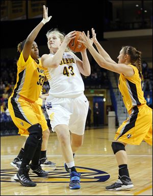 University of Toledo basketball player Sophie Reecher (43) drives between Valparaiso University players Sharon Karungi (33) and Lexi Miller (21)  during the first today.