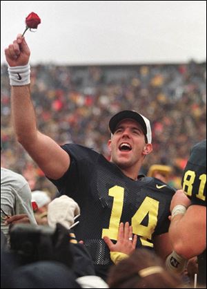 Michigan quarterback Brian Griese (14), acknowledges the crowd with a rose in his hand after he led the Wolverines to a 20-14 win over Ohio State at Michigan Stadium in Ann Arbor, Saturday, Nov. 22, 1997. 