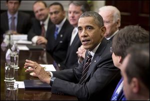 President Obama, with Vice President Joe Biden, gestures while speaking to the media before meeting with newly elected mayors  to discuss job creation, income equality, and several other topics.