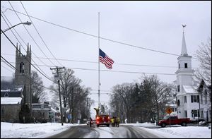 On the first anniversary of the Sandy Hook massacre, firefighters lower the town's flag on Main Street to half-staff in honor of the victims, Saturday in  Newtown, Conn. 