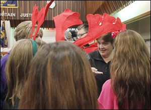 At right, Beth Schwandt, operations manager for the Salvation Army, instructs Penta volunteers — who are wearing reindeer ears — on how to help families at the giveaway.