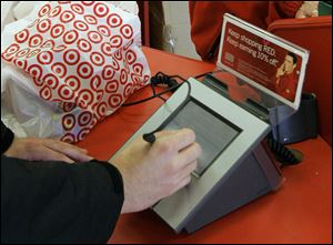 A customer signs his credit card receipt at a Target store in Tallahassee, Fla.