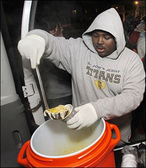 St. John’s freshman Ommanuel Levesque serves soup at Helping Hands of St. Louis.