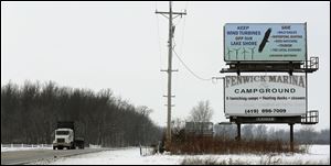 A billboard on State Rt. 2 lists some of the reasons that opponents of wind turbines in the area give for their lobbying against projects to harness the wind as an energy source locally. More turbines are proposed, but plans have not been filed with Ottawa County.