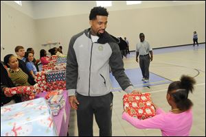 Wilson Chandler, a Benton Harbor, Mich., native currently playing for the NBA's Denver Nuggets, hands out Christmas presents at the Boys & Girls Club of Benton Harbor, Mich.