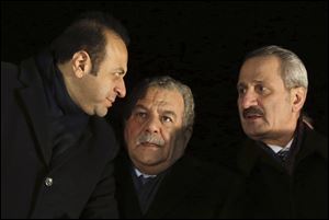 Turkey's Economy Minister Zafer Caglayan, right, Interior Minister Muammer Guler, center, and EU Affairs Minister Egemen Bagis speak at the Esenboga Airport in Ankara, Turkey Tuesday. Guler and Caglayan resigned from their posts today, days after their sons were arrested in a massive corruption and bribery scandal.