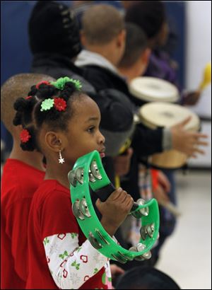 Mariah Gordon, 5, plays a tam-bourine during the celebration.
