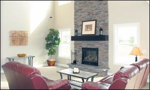 The great room’s stone fireplace rises two stories, making a grand statement. 