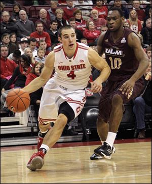 Ohio State's Aaron Craft, left, drives the baseline against Louisiana-Monroe's Amos Olatayo during the first half.