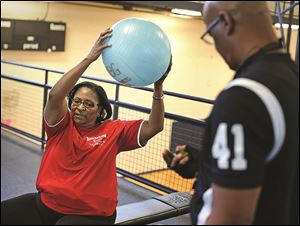 Karen Wright, left, does low-impact exercises under the supervision of personal trainer Harry Wright.