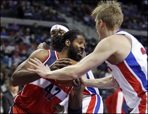 Washington Wizards forward Nene (42) drives against Detroit Pistons guard Kyle Singler, right, during the first half of an NBA basketball game, Monday, Dec. 30, 2013, in Auburn Hills, Mich. (AP Photo/Duane Burleson)