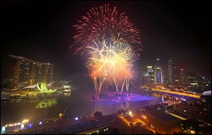 Fireworks explode over the financial district at midnight, Wednesday, Jan. 1, 2014 in Singapore. Celebrations started on New Year's Eve where concerts were held and thousands gathered on the streets to usher in the Year 2014. (AP Photo/Wong Maye-E)