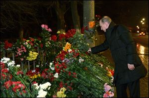Russian President Vladimir Putin places flowers outside the wreckage of a trolleybus in Volgograd, Russia, today.