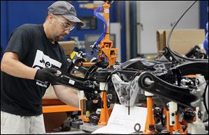 An employee works on suspensions for the new Jeep Cherokee at the Toledo Assembly Complex.