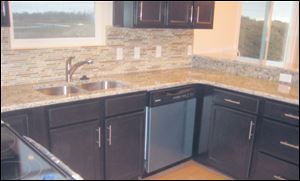 Granite countertops meet with tiled backsplash in neutral tones.