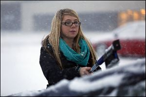 Melanie Corrigan, 20, gets ready to leave the empty parking lot at Franklin Park Mall after it closed early during a snowstorm on Sunday. Corrigan works at Aerie and was allowed to go home early due to the snow.